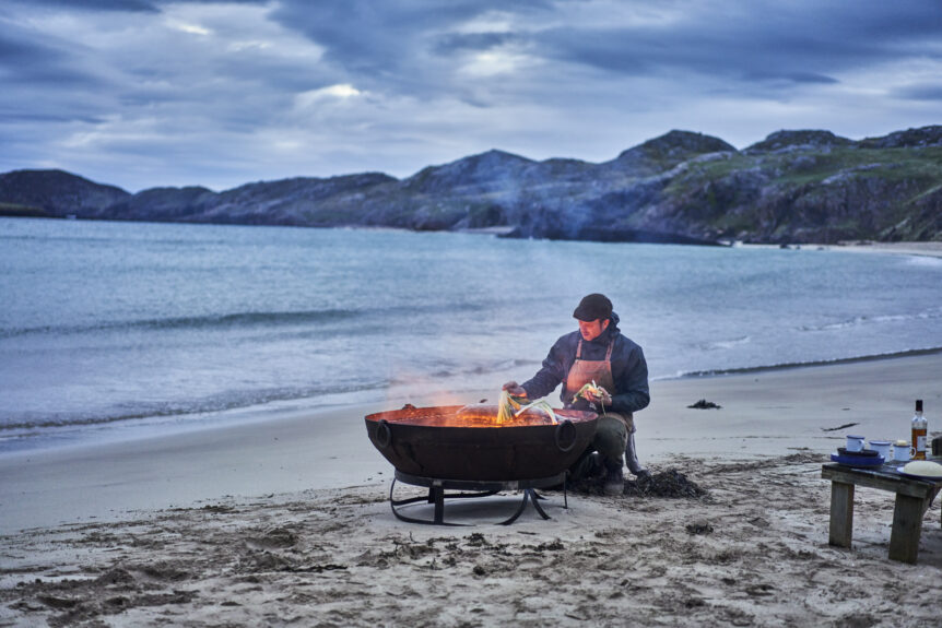 man on beach with barbecue