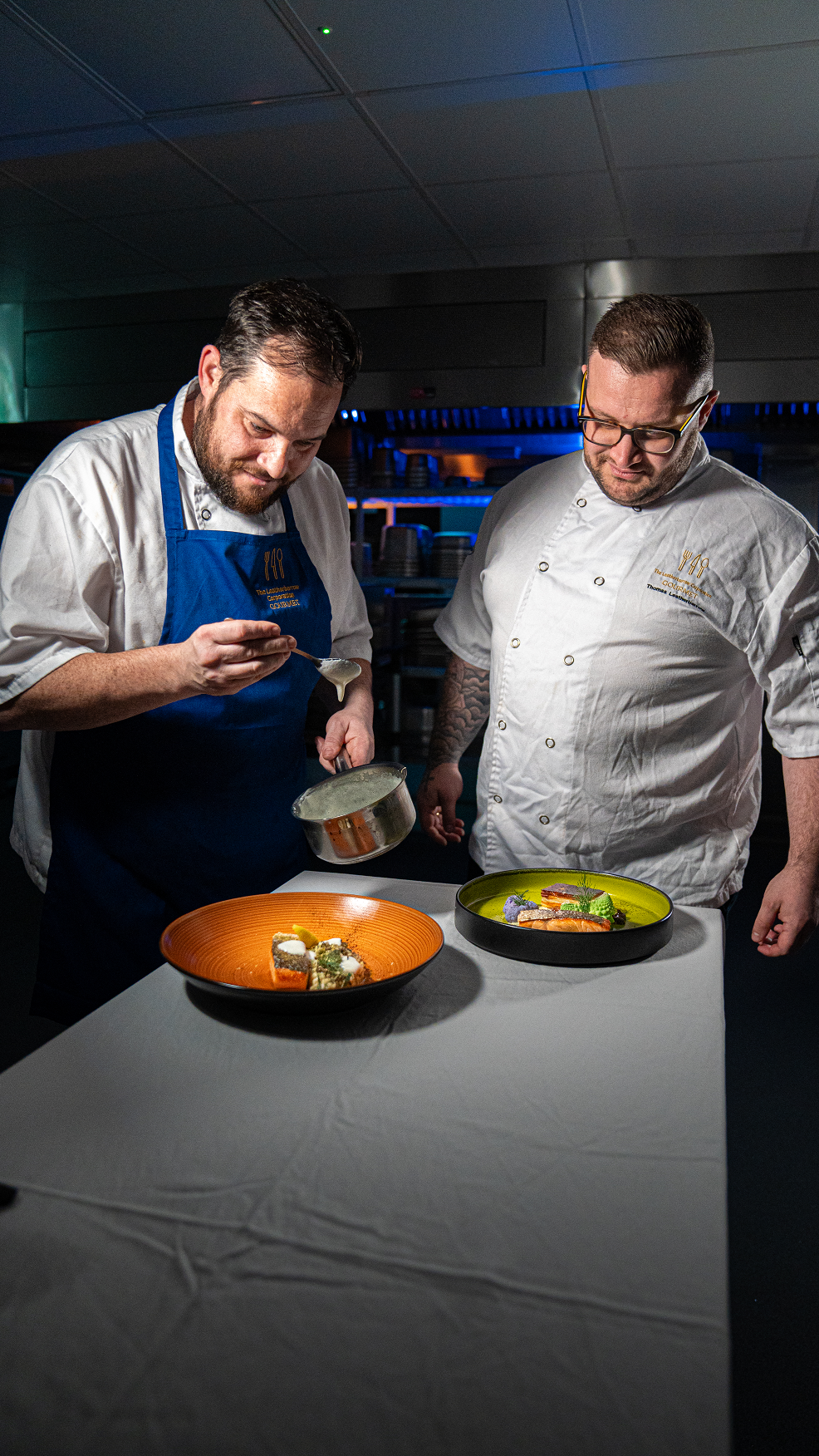 two chefs look at plates of loch duart salmon
